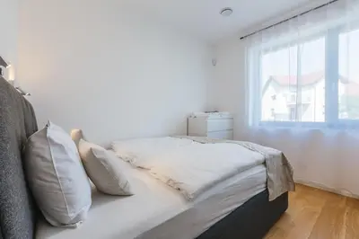 a white bed with pillows in a room with a window at HIRUNDO- villa with saunas and hot tub in Sela pri Dobovi