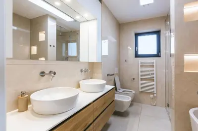a bathroom with two sinks and a toilet at HIRUNDO- villa with saunas and hot tub in Sela pri Dobovi