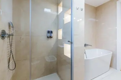 a bathroom with a shower with a glass door at HIRUNDO- villa with saunas and hot tub in Sela pri Dobovi