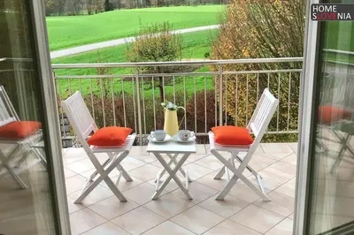 a patio with two chairs and a table with red pillows at HomeSlovenia - your Home in the Heart of Slovenia in Selca