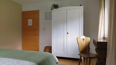 a bedroom with a bed and a cabinet and a chair at HomeSlovenia - your Home in the Heart of Slovenia in Selca