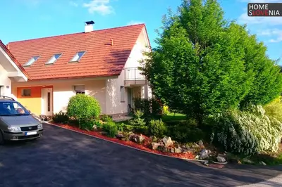 a house with a car parked in front of it at HomeSlovenia - your Home in the Heart of Slovenia in Selca