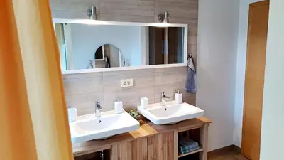 a bathroom with two sinks and a mirror at HomeSlovenia - your Home in the Heart of Slovenia in Selca