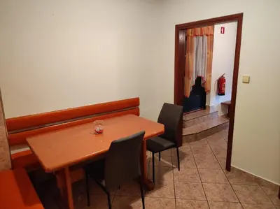 a dining room with a wooden table and chairs at Turistična kmetija Štupar in Dvor