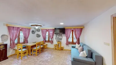 a living room with a blue couch and a table at hiša Margit, Rateče 150 in Rateče