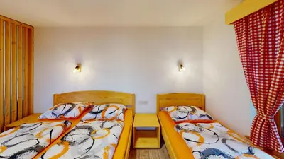 a bedroom with two beds and a window at hiša Margit, Rateče 150 in Rateče