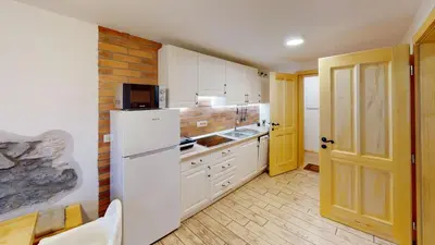 a kitchen with white cabinets and a white refrigerator at hiša Margit, Rateče 150 in Rateče