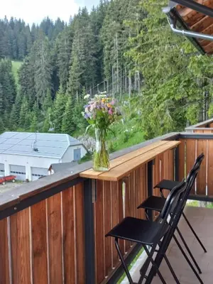 a vase of flowers sitting on top of a balcony at Primorka Golte in Mozirje