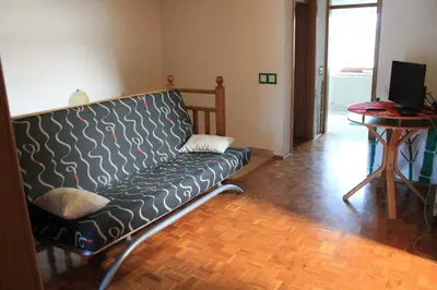 a black couch in a living room with a table at Prijeten prostoren apartma v hiši in Pivka