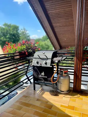 a grill sitting on a balcony on a patio at Prijeten prostoren apartma v hiši in Pivka