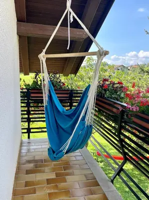 a blue hammock hanging from a porch at Prijeten prostoren apartma v hiši in Pivka