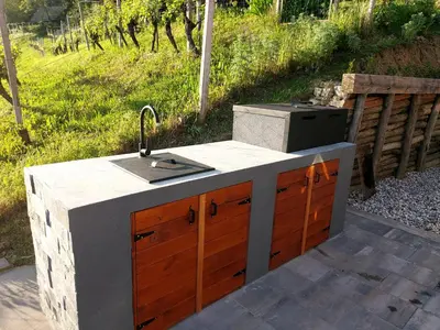 a outdoor kitchen with a sink and a stove at Hiška oddiha - Rest house in Sromlje
