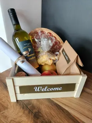 a wooden box with a bottle of wine and fruit at Hiška oddiha - Rest house in Sromlje