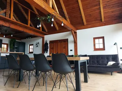 a living room with a table and black chairs at Hiška oddiha - Rest house in Sromlje