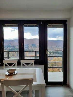 a room with a table and windows with a view at Vineyard cottage Kulovec in Uršna Sela