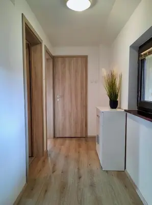 an empty living room with a door and wooden floors at Vineyard cottage Kulovec in Uršna Sela