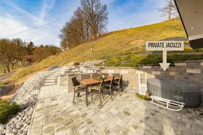 a patio with a table and a bbq and a hill at Holiday House Vikend in Polzela