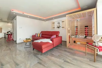 a living room with a red couch and a table at Holiday House Vikend in Polzela