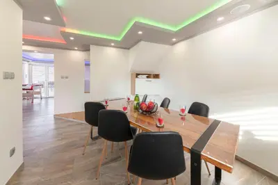 a dining room with a table and black chairs at Holiday House Vikend in Polzela