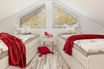two beds in a room with two windows at Holiday House Vikend in Polzela