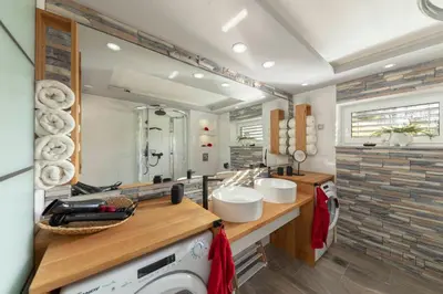 a bathroom with a sink and a washing machine at Holiday House Vikend in Polzela
