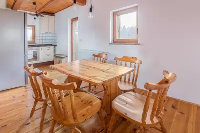a dining room with a wooden table and chairs at Svisla in Kranj
