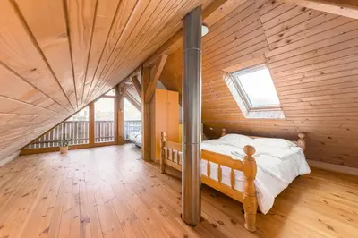 a bedroom with a bed in a wooden house at Svisla in Kranj