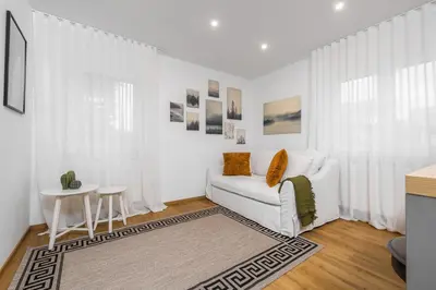 a living room with a white couch and a table at Apartmaji Spalina, Ivančna Gorica in Veliko Črnelo