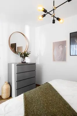 a bedroom with a bed with a mirror and a dresser at Apartmaji Spalina, Ivančna Gorica in Veliko Črnelo