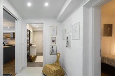 a white hallway with a chair and a bedroom at Apartmaji Spalina, Ivančna Gorica in Veliko Črnelo