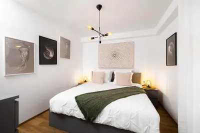 a bedroom with a large bed with white walls at Apartmaji Spalina, Ivančna Gorica in Veliko Črnelo