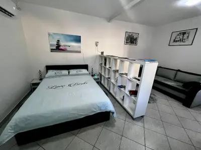 a bedroom with a large bed and a couch at Apartma B & O in Idrija