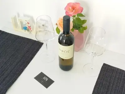 a bottle of wine and two glasses on a table at Apartma B & O in Idrija