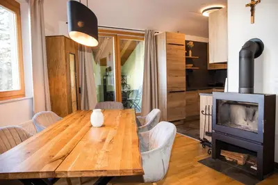 a dining room with a wooden table and a fireplace at Apartment - Golden Fox 18 - Pohorske terase in Pohorje