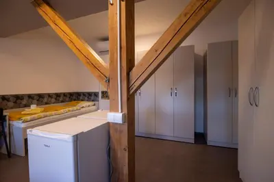 a kitchen with white cabinets and a table at Hostel Veronika Celje in Celje