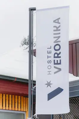 a white banner hanging from a pole in front of a building at Hostel Veronika Celje in Celje