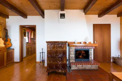 a living room with a fireplace and wooden ceilings at Chalet Vista in Cerklje na Gorenjskem