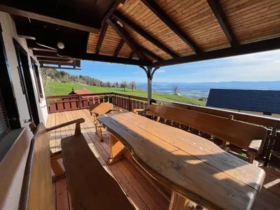 a wooden bench sitting on a deck with a view at Chalet Vista in Cerklje na Gorenjskem