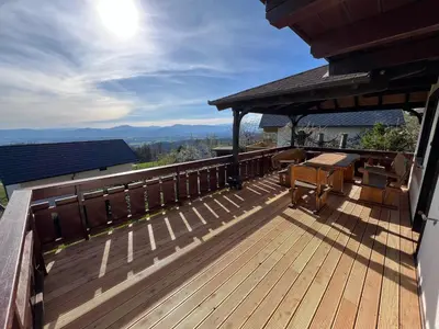 a deck with a table and chairs on a house at Chalet Vista in Cerklje na Gorenjskem