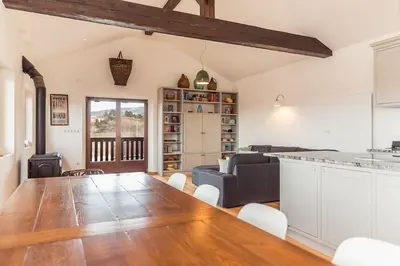 a kitchen and living room with a large wooden table at Cherry Orchard House in Šmartno
