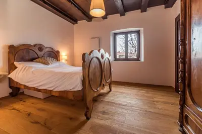 a bedroom with a wooden bed and a window at Cherry Orchard House in Šmartno