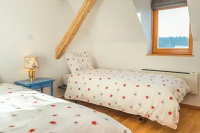 a bedroom with two beds and a window at Dandelion House in Podjelje