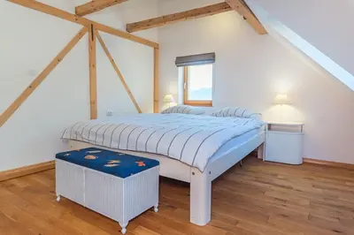 a bedroom with a bed with a blue and white comforter at Dandelion House in Podjelje