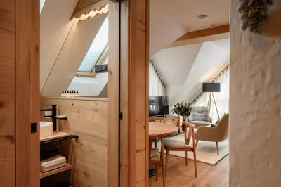 an attic kitchen and dining room with a table and chairs at Vila Pavlina in Kranjska Gora