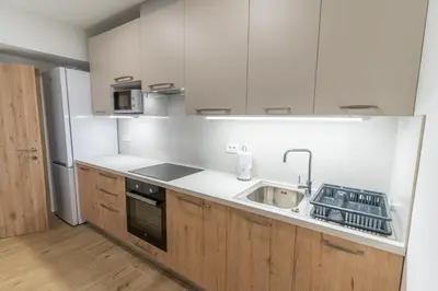 a kitchen with white cabinets and a sink and a stove at Apartma Valič in Ajdovščina