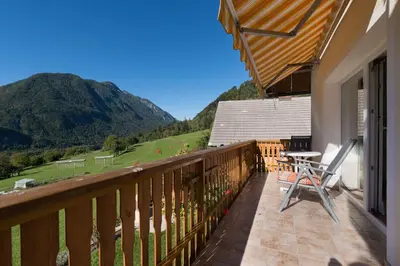 a balcony with a table and chairs and a mountain at Ela Apartments - 1 in Kranjska Gora