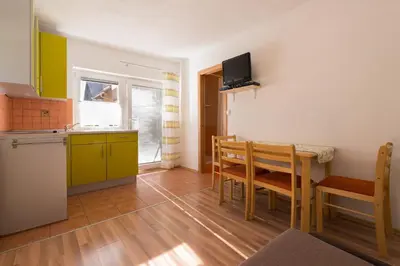 a kitchen and a dining room with a table and chairs at Ela Apartments - 2 in Dovje