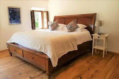 a bedroom with a large bed with a wooden headboard at Escape to Bohinj House in Bohinj