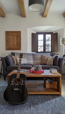 a guitar sitting in a living room with a couch at Escape to Bohinj House in Bohinj