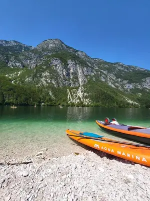 two boats sitting on the shore of a lake at Escape to Bohinj House in Bohinj